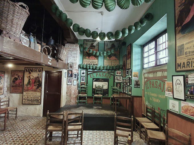 Interior del Tabanco El Pasaje con botas de vino, barra de madera y espectáculo de flamenco en directo.